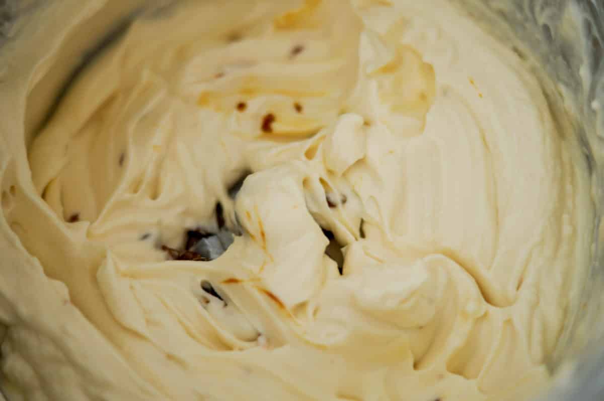 Stirring caramel into the cream in the mixing bowl