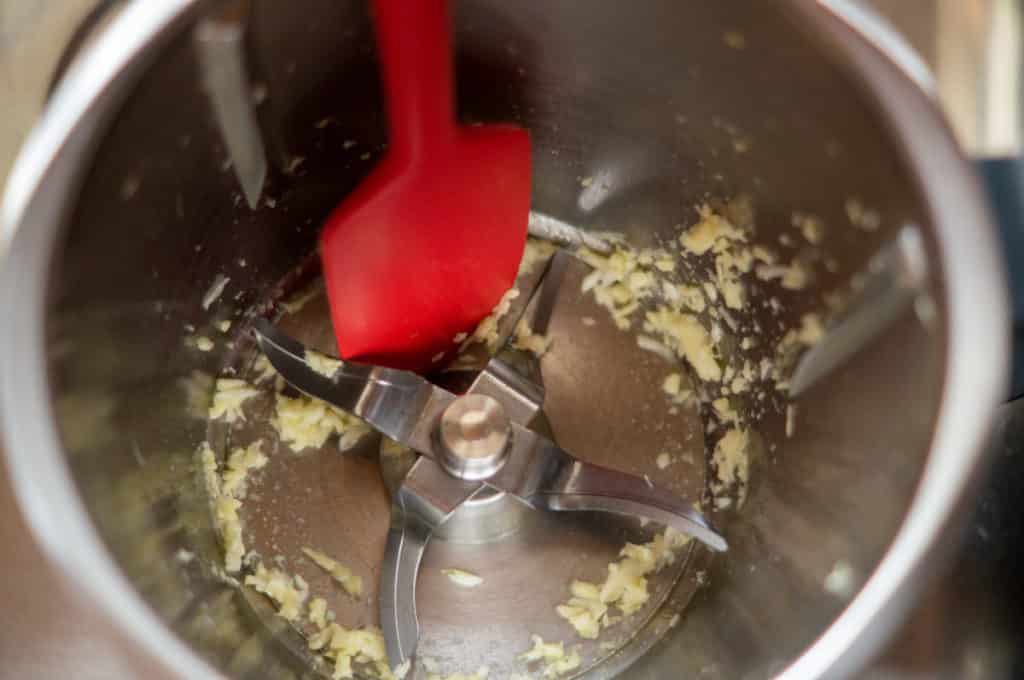 Chopping garlic in the Thermomix® mixing bowl with the spatula