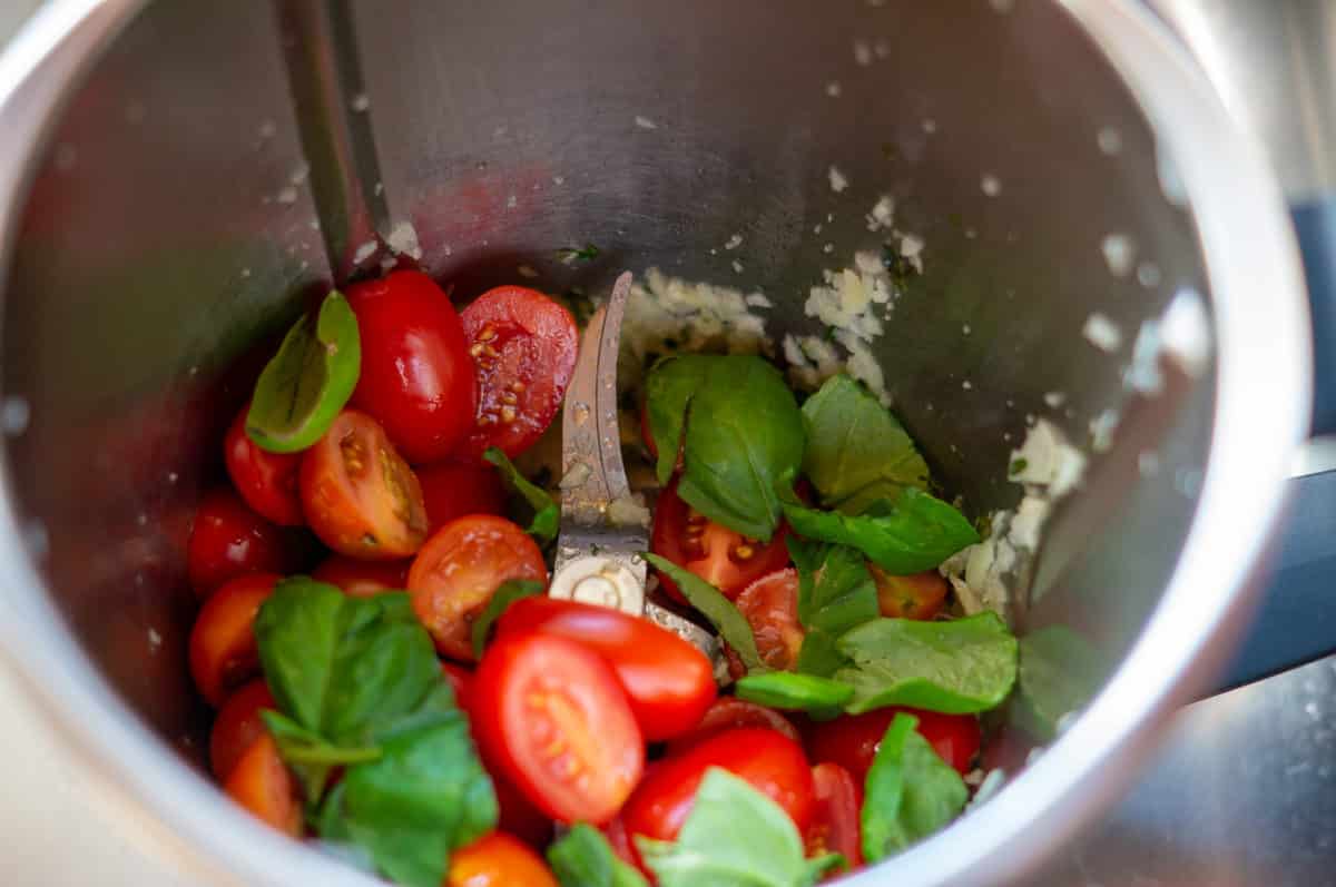 Cherry tomatoes and fresh basil in the Thermomix® mixing bowl before blending