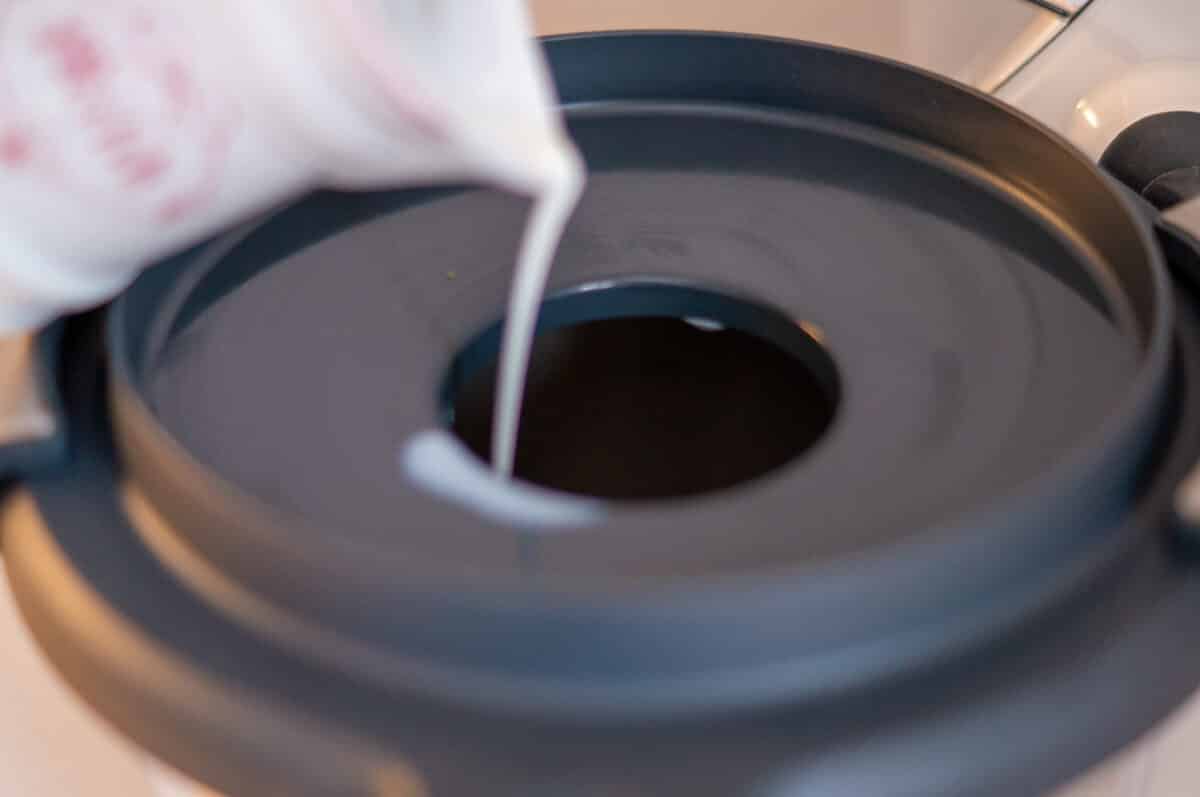 Adding milk to the mixing bowl