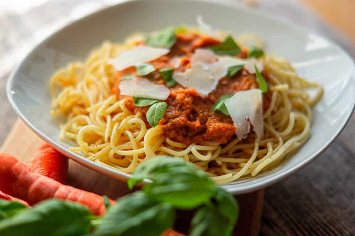 Carrot and tomato spaghetti made with the Thermomix® with Parmesan and basil on a plate