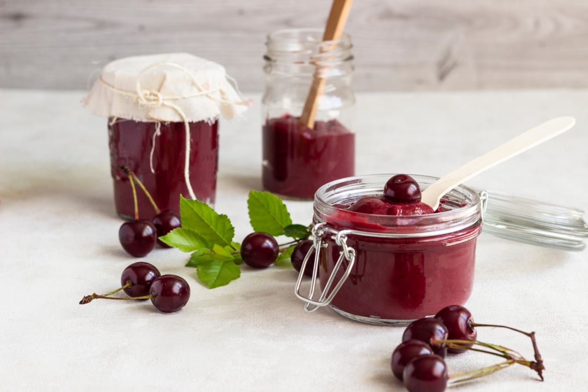Freshly filled cherry jam in preserving jars made with the Thermomix®