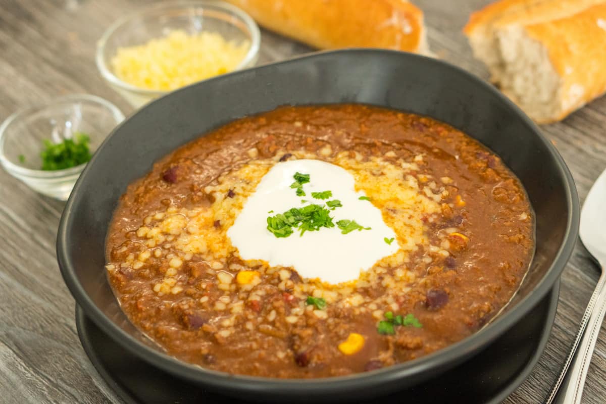 Chili con Carne in the Thermomix® during cooking, mixing bowl with lid on the machine