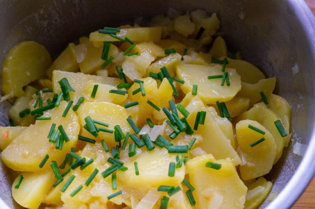 Scattering chives over the potato salad