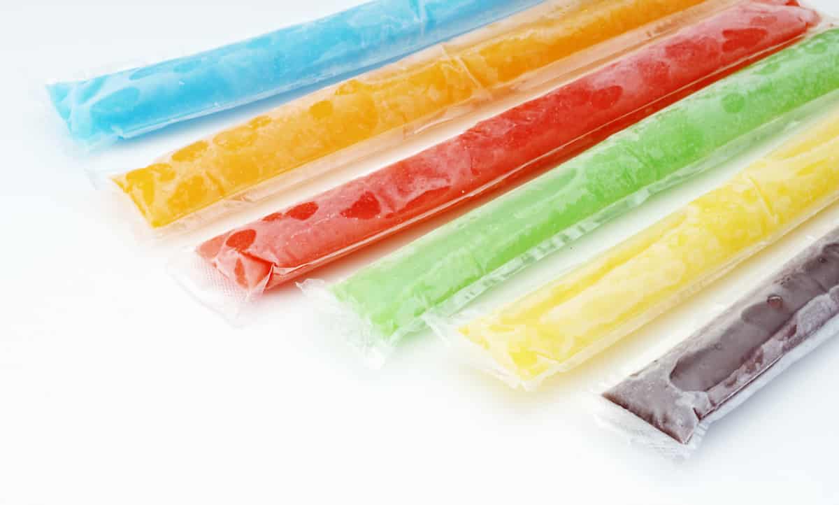Cola ice lolly made with the Thermomix® on a stick, on a plate