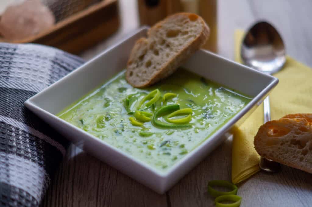 Creamy leek soup from the Thermomix® in a bowl, ready to serve with baguette