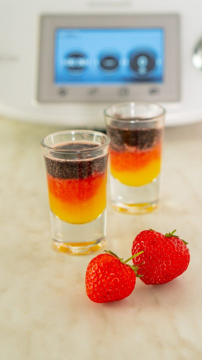 Football shots made with the Thermomix® in the colours of the German flag: three layers of mango, strawberry and blueberry in shot glasses
