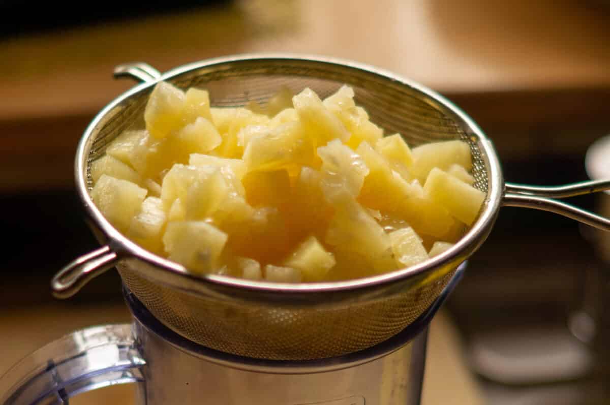 Draining tinned pineapple