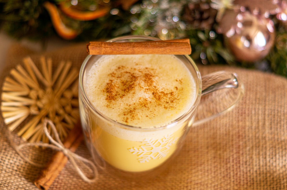 Hot eggnog served in a glass with cinnamon and nutmeg