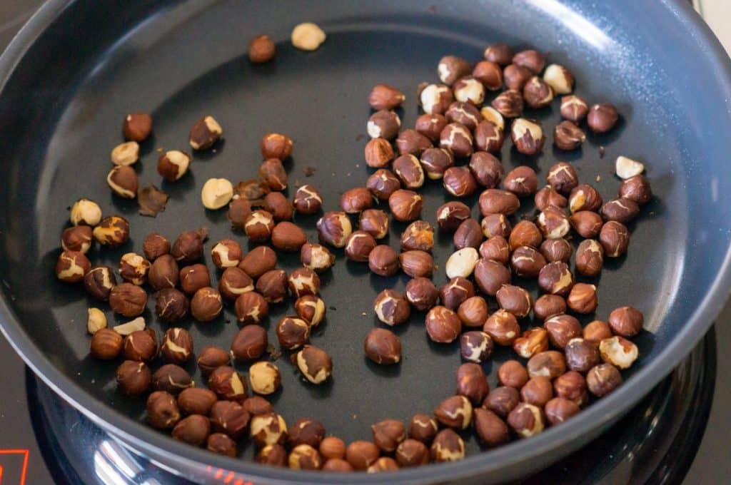 Toasting hazelnuts in a frying pan
