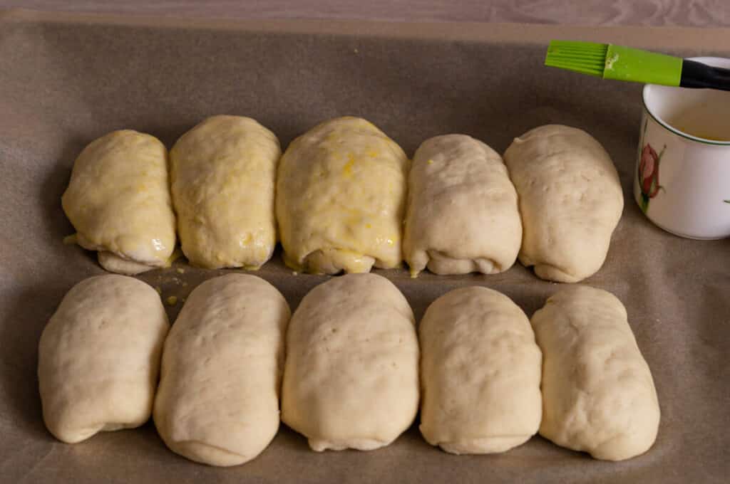 Milk rolls on the baking tray before baking, brushed with egg yolk