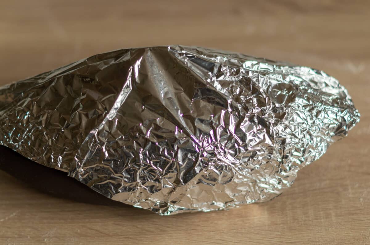 Dough proving in the bread tin covered with foil