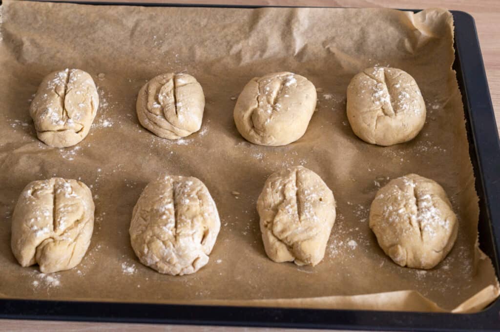 Proved potato roll portions on a baking tray