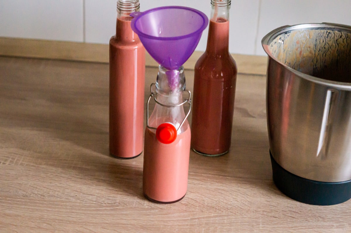 Filling pink liqueur into bottles