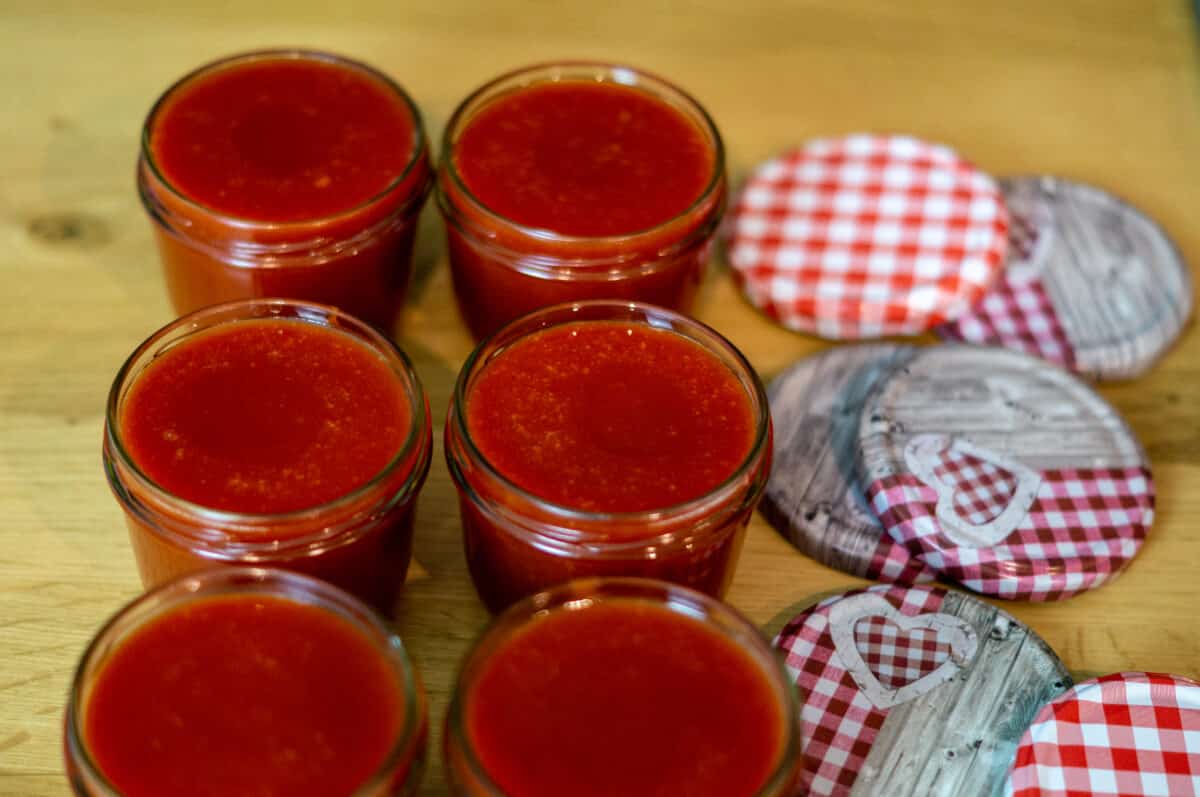 Filling rosehip jam into sterilised jars
