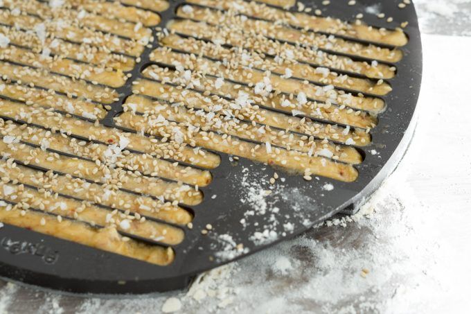 Sprinkling sesame seeds on the breadsticks