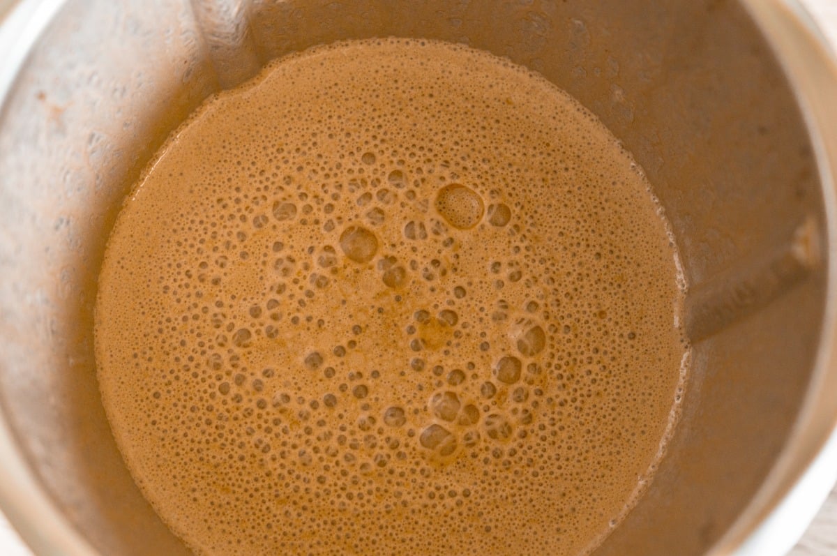 Ice cubes, date paste and milk in the mixing bowl
