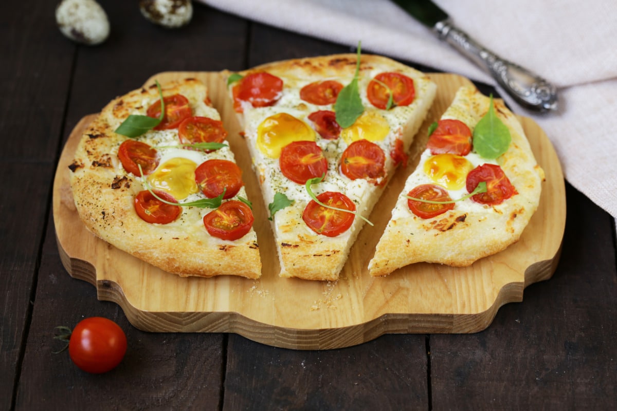 Tomato focaccia made with the Thermomix® topped with red and yellow cherry tomatoes and basil