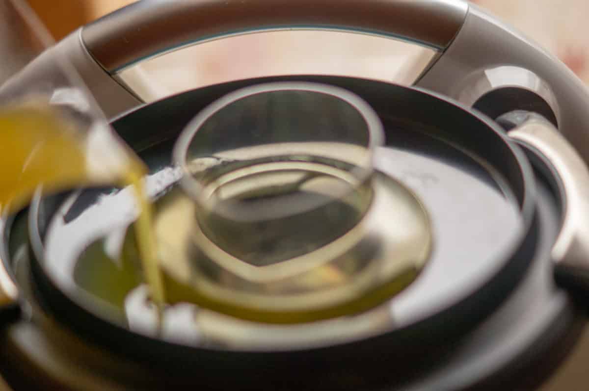 Butter dripping slowly from the mixing bowl lid into the hollandaise