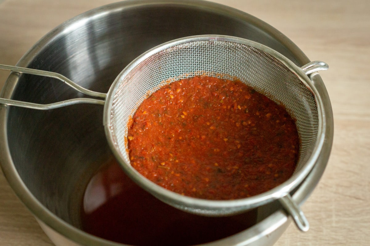 Pressing tomato puree through a sieve