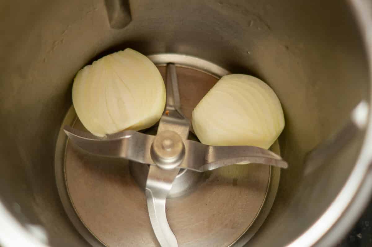 Halving the onion and placing it in the mixing bowl