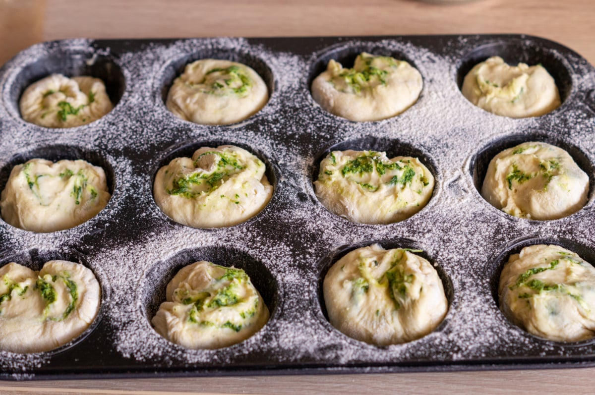 Wild garlic potato roll dough pieces in muffin tin