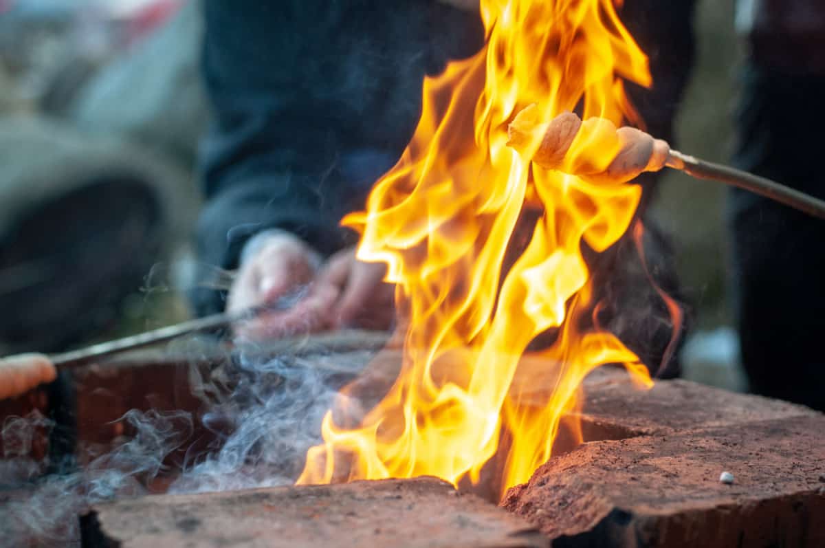 Thermomix® campfire bread turning over the glowing embers